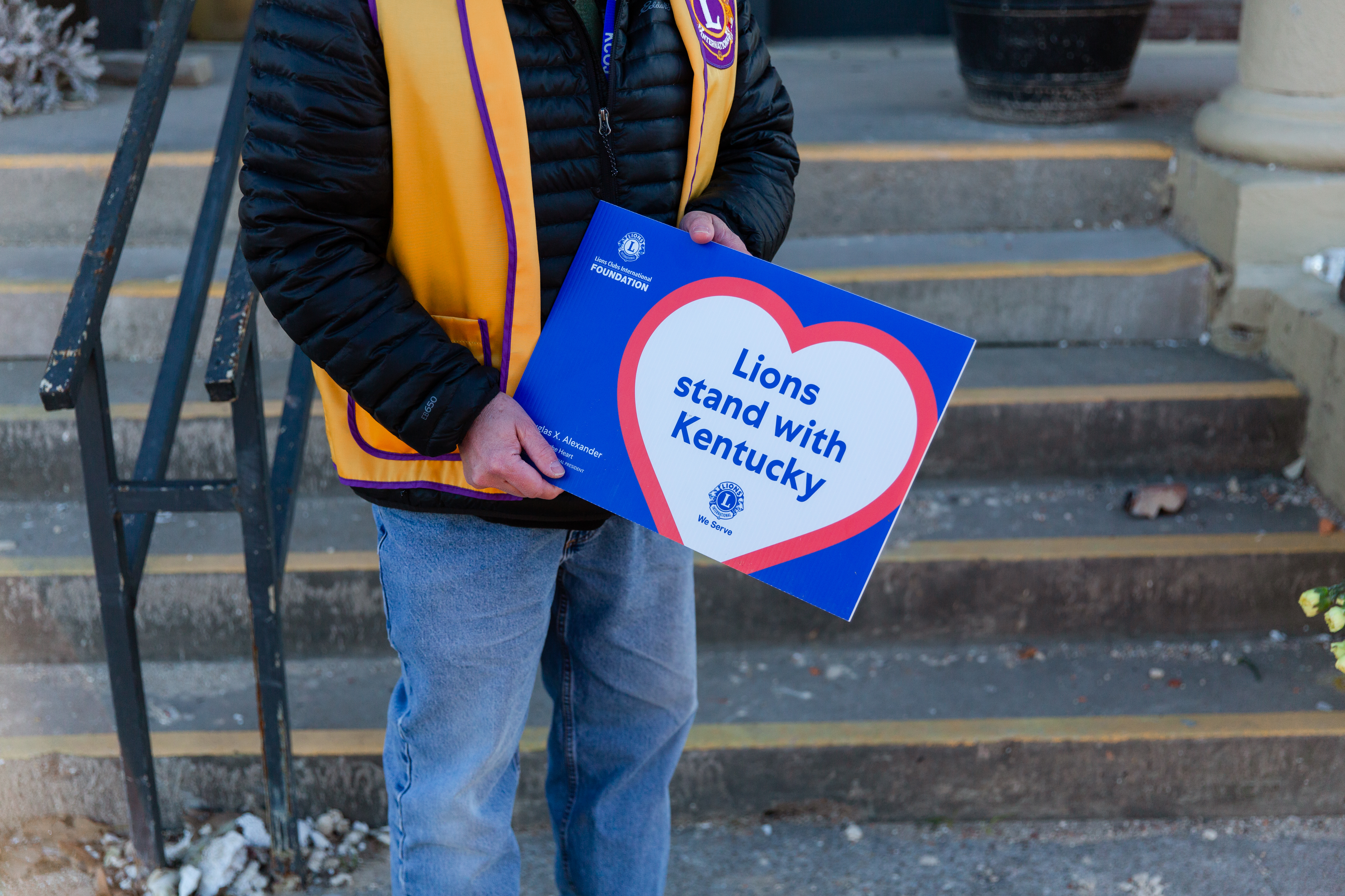 Lion member holding a Lions stand with Kentucky sign