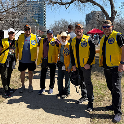 Dallas Founder Lions Club members stand together outdoors in their yellow vests, ready to participate in a community event.
