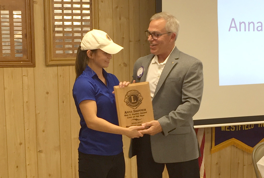 Skinner receives the Lion of the Year award from the Westfield Lions Club Secretary Jeff Larrison.
