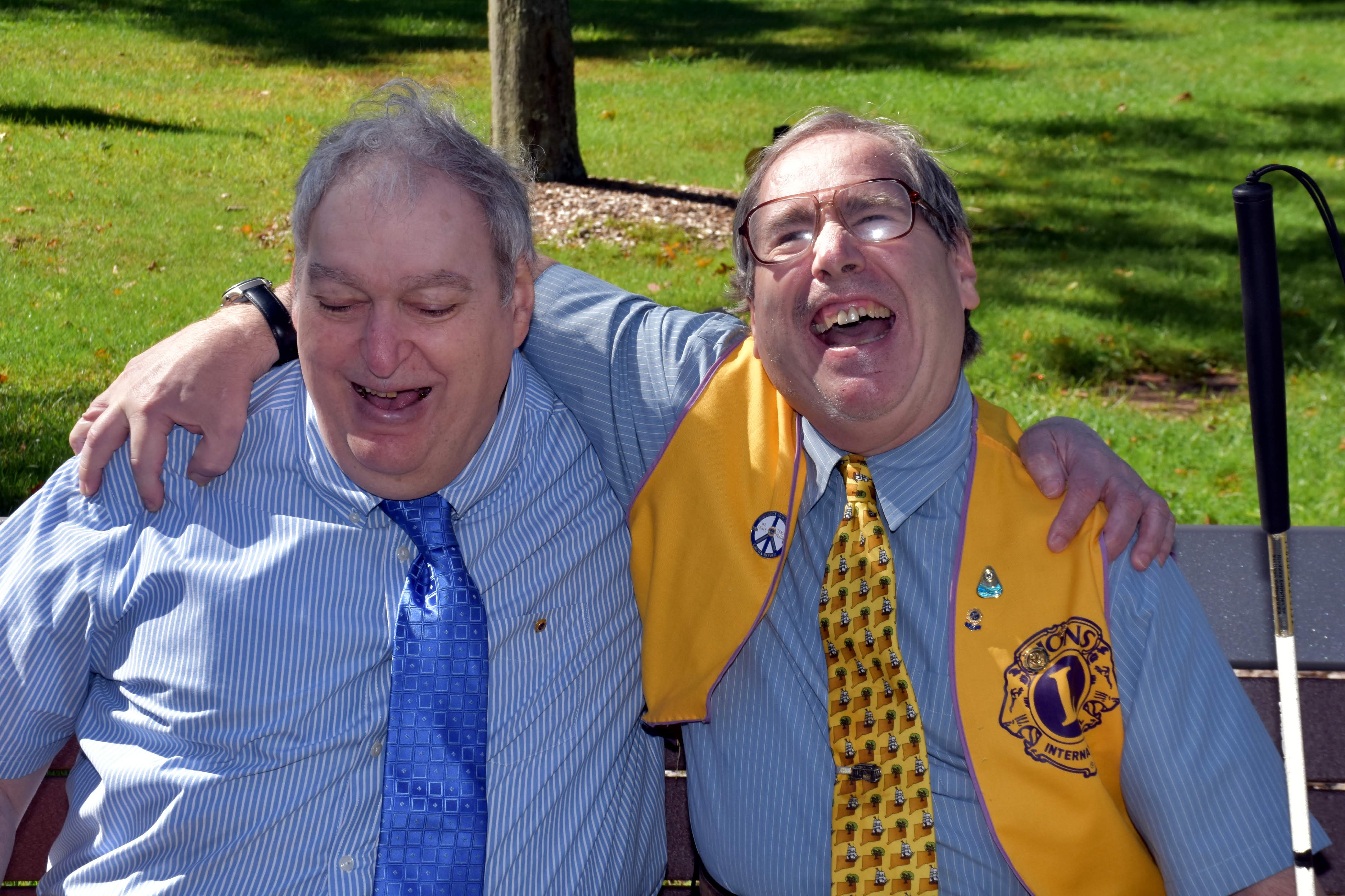 分区主席霍华德．盖特曼(左)与马地．奈特狮友一同在纪念奈特45年来的服务之座椅上欢笑。