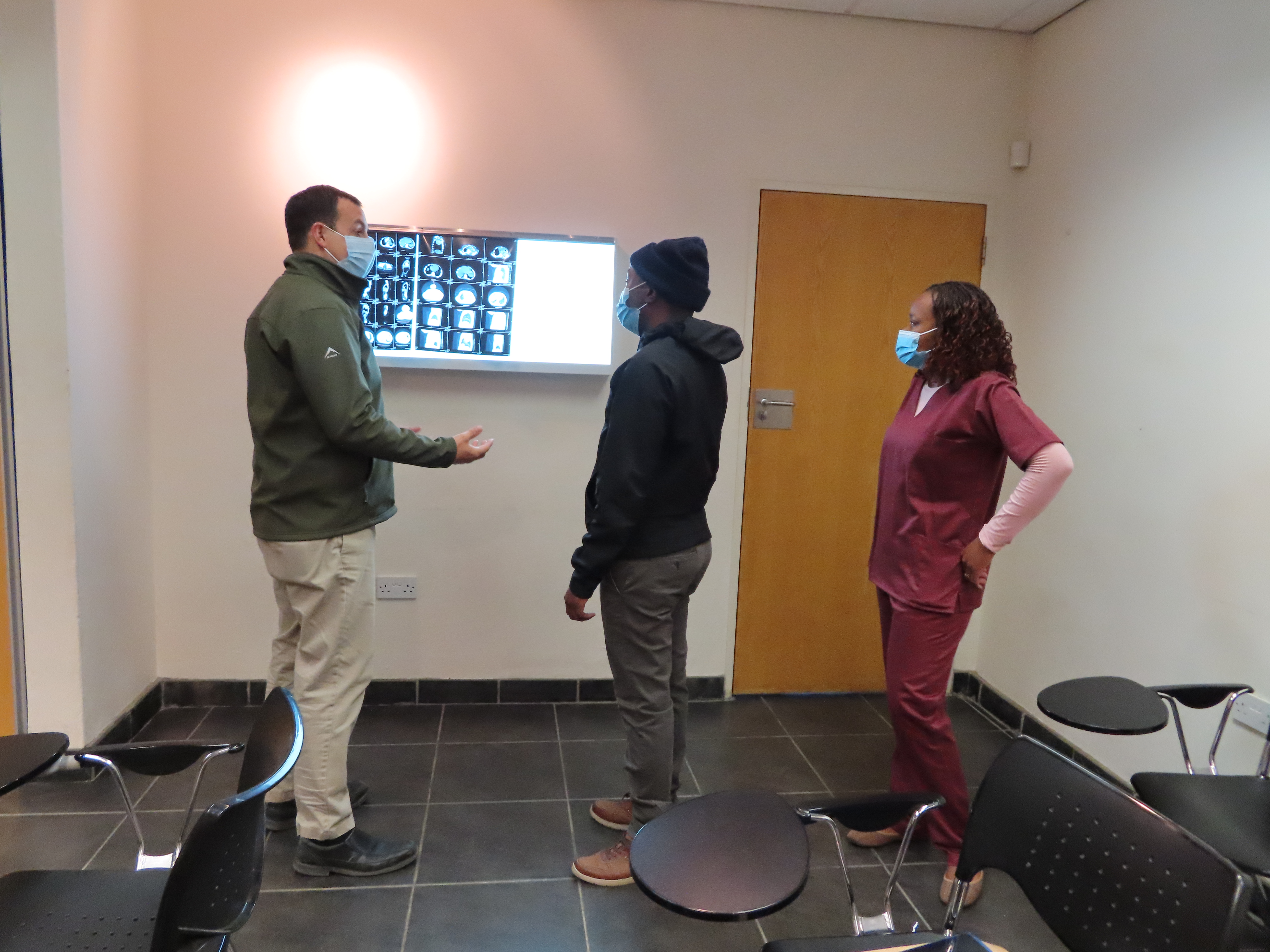 Dr. Sloane discusses MRI images with two fellows at the Botswana Global HOPE Center for Excellence.