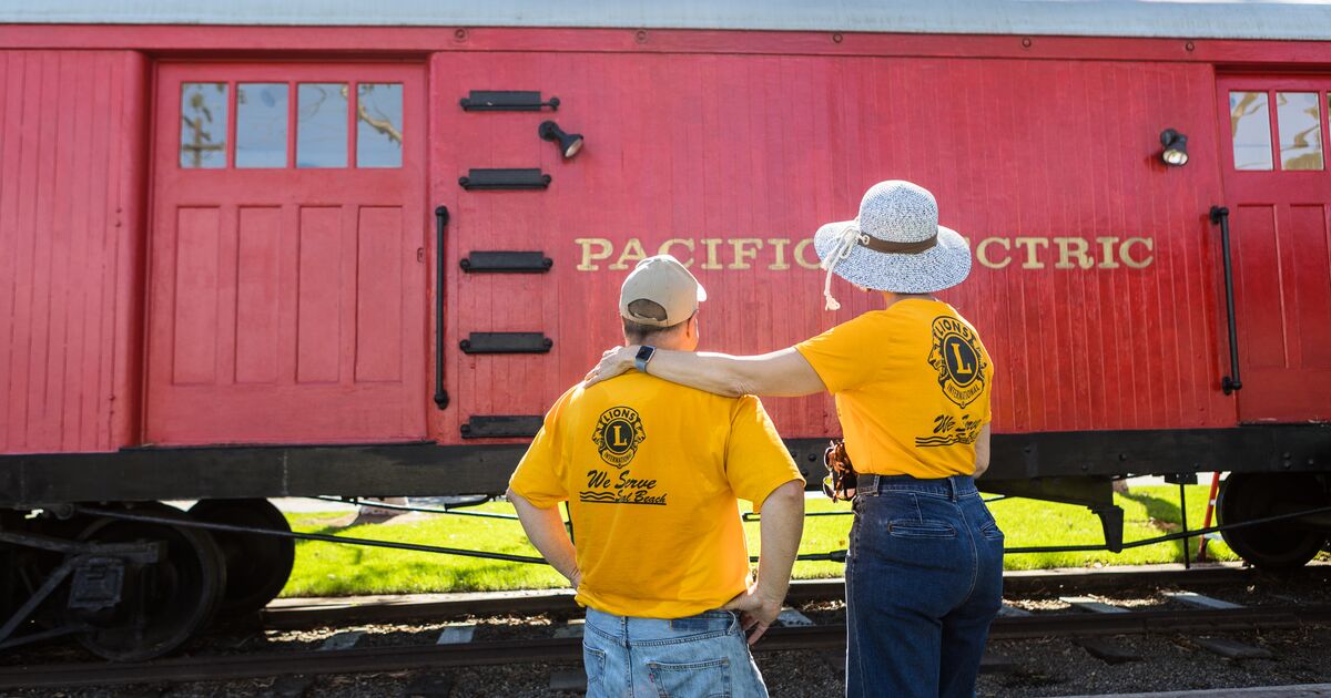 Backs of Lion members looking at train car project