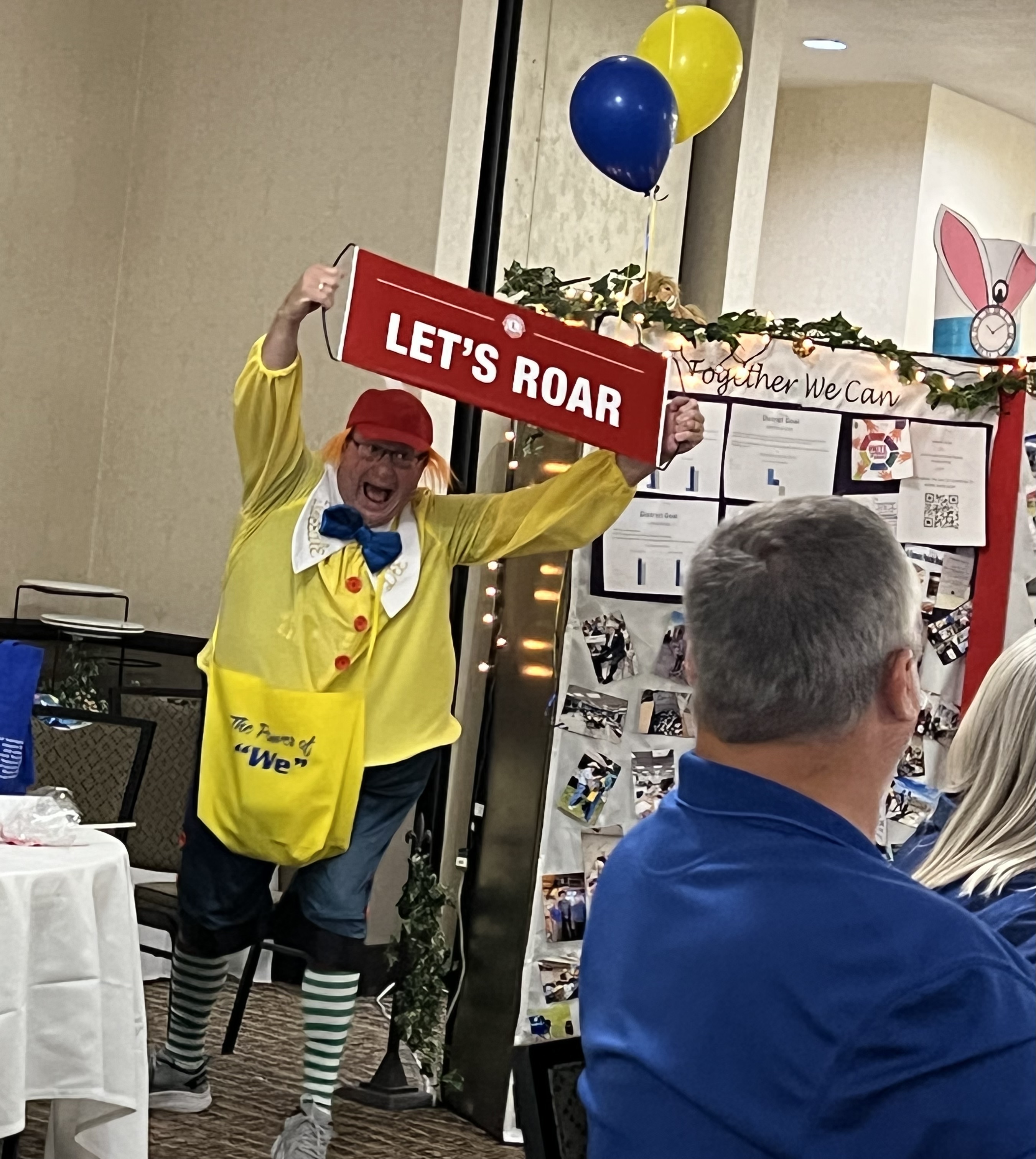 Photo of Lion member holding a Let's Roar sign