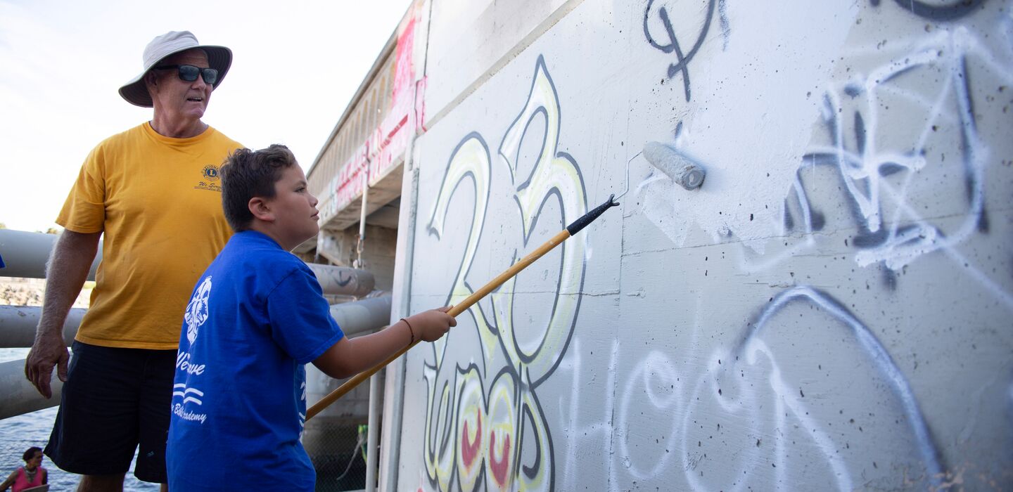Un socio Lion osserva il socio Leo durante un progetto per ripulire i muri dai graffiti
