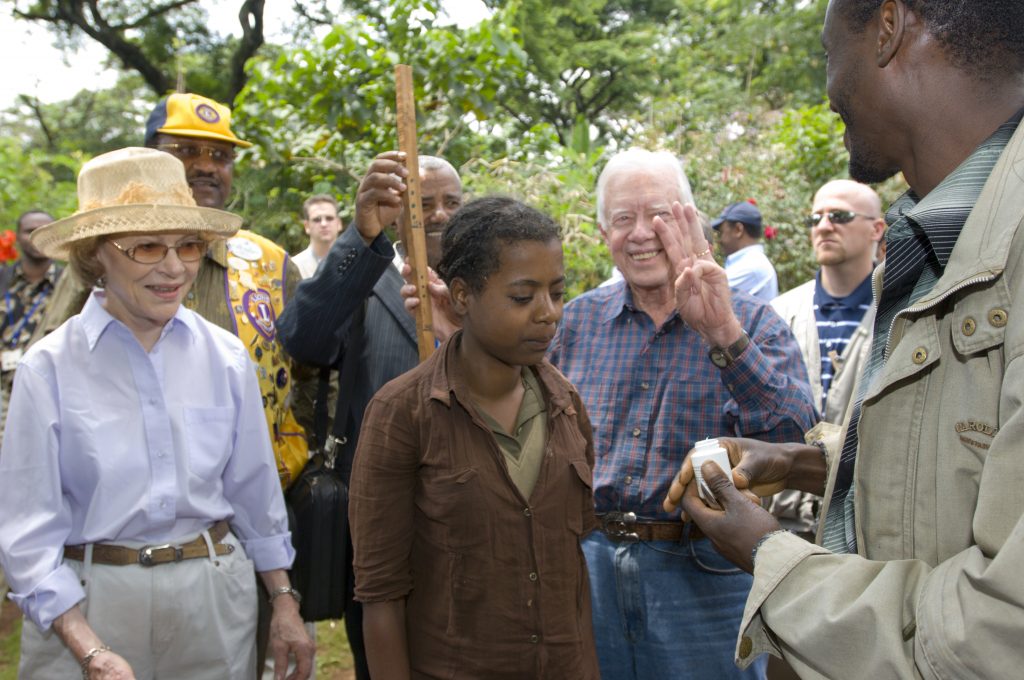 Ethiopia, February 13, 2007: President Jimmy Carter and his wife Rosalynn visit health projects supported by the Carter Center in this remote rural area of Ethiopia. Here, the President and Mrs. Carter help measure people to determine how many prophylactic onchocerciasis (River Blindness) Mectizan pills should be given to them. President Carter holds up three fingers to indicate how many pills. For use only with permission of The Carter Center, Atlanta, Ga, USA. Credit: The Carter Center
